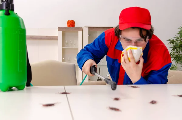 Jovem empreiteiro fazendo controle de pragas em casa — Fotografia de Stock