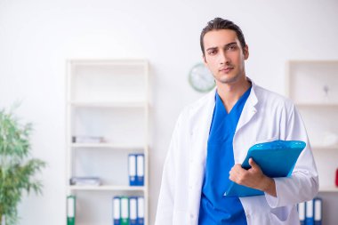Klinikte çalışan genç erkek doktor.