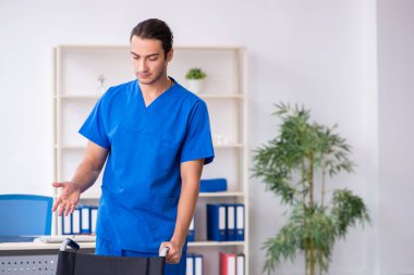 Klinikte çalışan genç erkek doktor.