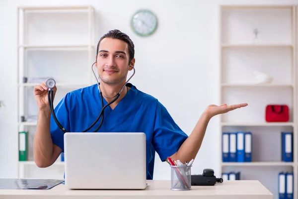 Jonge mannelijke arts werkzaam in de kliniek — Stockfoto