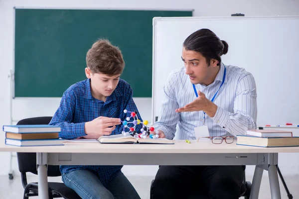 Jovem professor do sexo masculino explicando modelo molecular — Fotografia de Stock