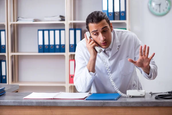 Ung manlig läkare i receptionen på sjukhuset — Stockfoto