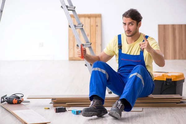 Jovem empreiteiro do sexo masculino trabalhando dentro de casa — Fotografia de Stock