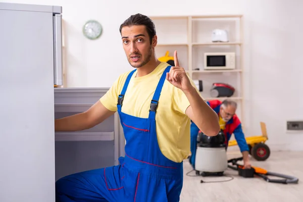 Twee aannemers repareren koelkast in werkplaats — Stockfoto
