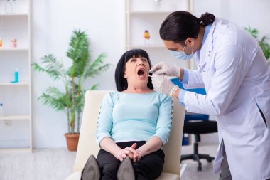 Yaşlı kadın genç dişçiyi ziyaret ediyor.