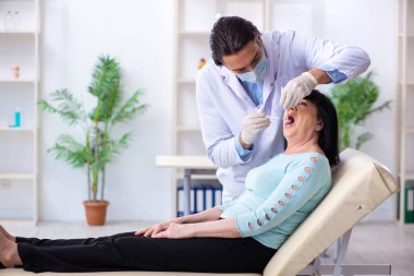 Yaşlı kadın genç dişçiyi ziyaret ediyor.