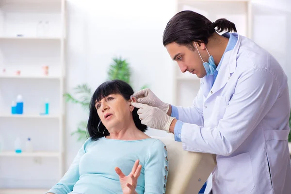 Velha mulher visitando jovem médico laringologista — Fotografia de Stock