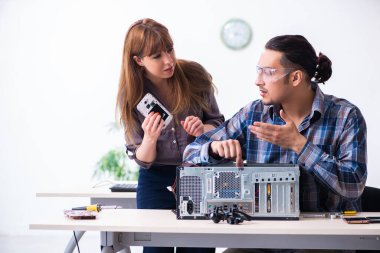 Bilgisayar garanti merkezinde çalışan iki teknisyen.
