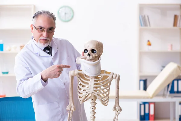 Homme âgé médecin avec squelette — Photo