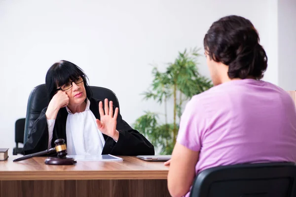 Young man consulting with judge on litigation issue — Stock Photo, Image