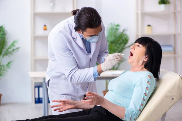 Oude vrouw bezoekt jonge dokter tandarts — Stockfoto