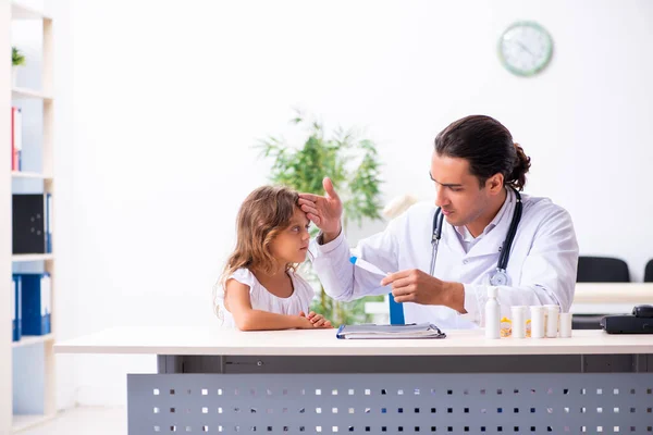 Küçük bir kızla genç bir doktor çocuk doktoru. — Stok fotoğraf