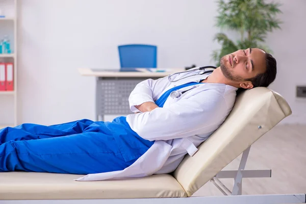 Young male doctor being tired after night shift — Stock Photo, Image