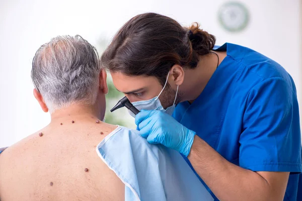 Viejo visitando joven médico dermatólogo — Foto de Stock