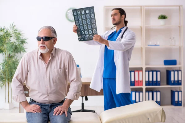 Yaşlı kör adam genç erkek doktoru ziyaret ediyor. — Stok fotoğraf