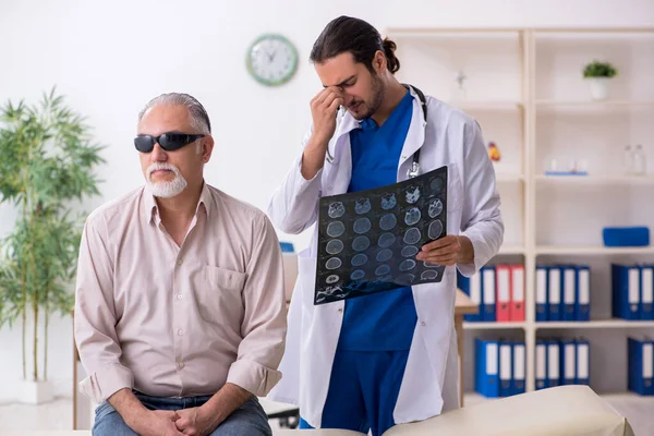Γέρος τυφλός επισκέπτεται νεαρό άνδρα γιατρό — Φωτογραφία Αρχείου