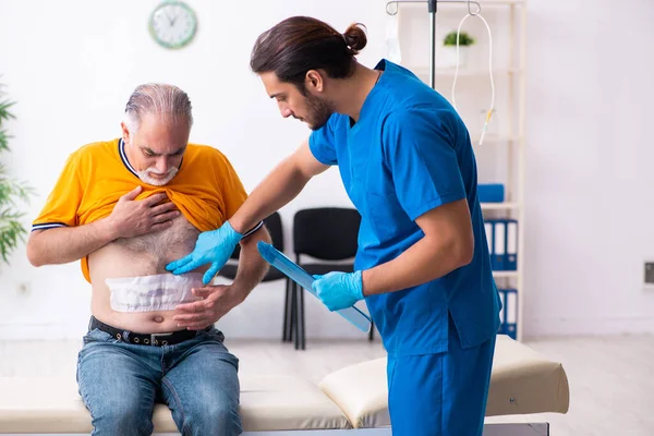 Alt mann besuch jung männlich doktor — Stockfoto