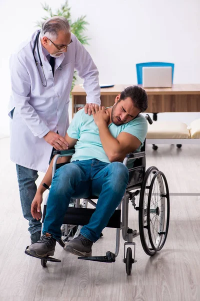 Tecrübeli doktor ve tekerlekli sandalyedeki genç hasta. — Stok fotoğraf