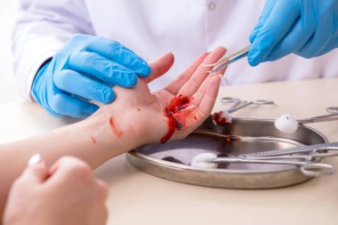 Yaralı kadın erkek doktoru ziyaret ediyor.