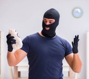 Soyguncu kar maskesi takıp değerli şeyler çalıyor.