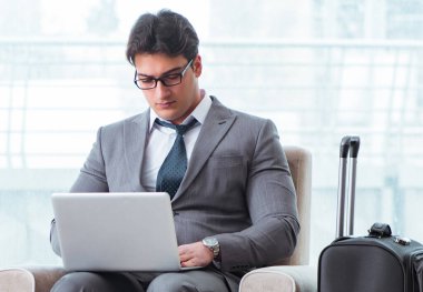 Havaalanındaki iş yerinde genç işadamı uçuş için bekliyor.