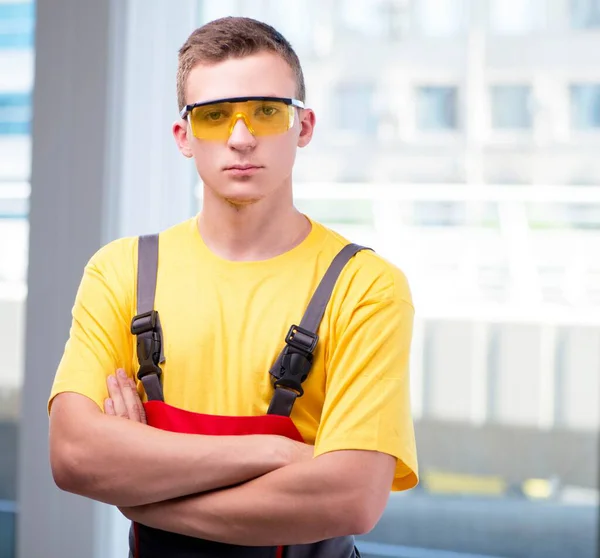 Joven trabajador de la construcción en mono amarillo — Foto de Stock