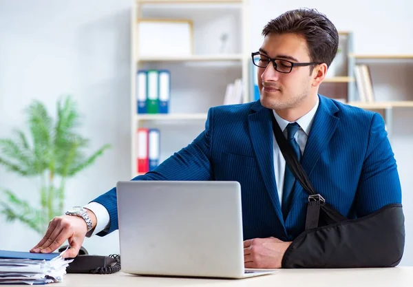 Uomo d'affari con braccio rotto che lavora in ufficio — Foto Stock