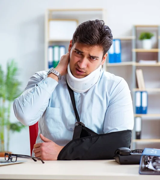 Uomo d'affari con braccio rotto che lavora in ufficio — Foto Stock