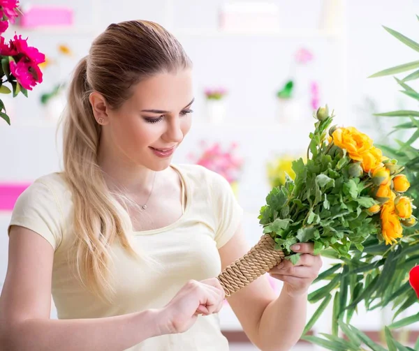 Ung kvinna vattna växter i sin trädgård — Stockfoto