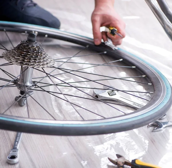 在家里修理自行车的年轻人 — 图库照片