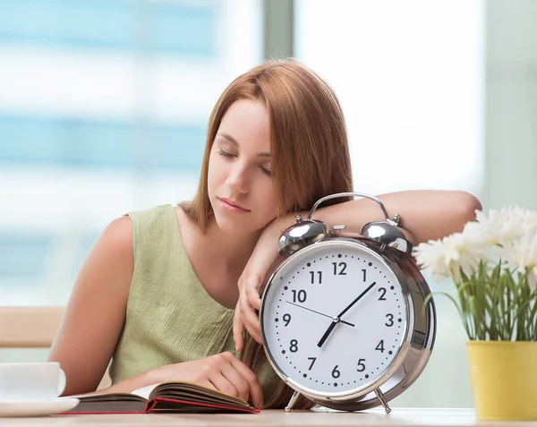 Student with gian alarm clock preparing for exams — Stock Photo, Image