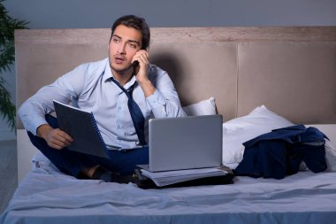 Yorgun işadamı gece fazla mesai yapıyor.