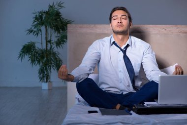 Yorgun işadamı gece fazla mesai yapıyor.