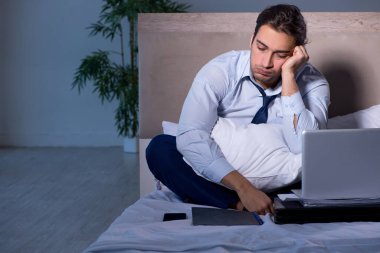 Yorgun işadamı gece fazla mesai yapıyor.