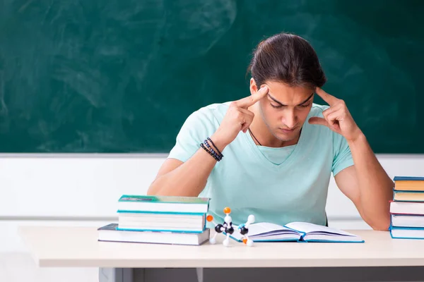 Ung manlig student sitter i klassrummet — Stockfoto