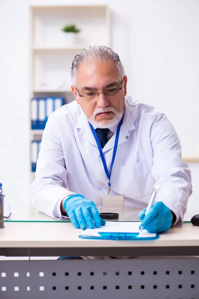 Alter Kriminologe arbeitet im Labor nach Beweisen — Stockfoto