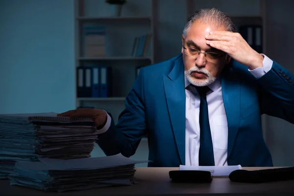 Gammal manlig anställd som arbetar sent på kontoret — Stockfoto