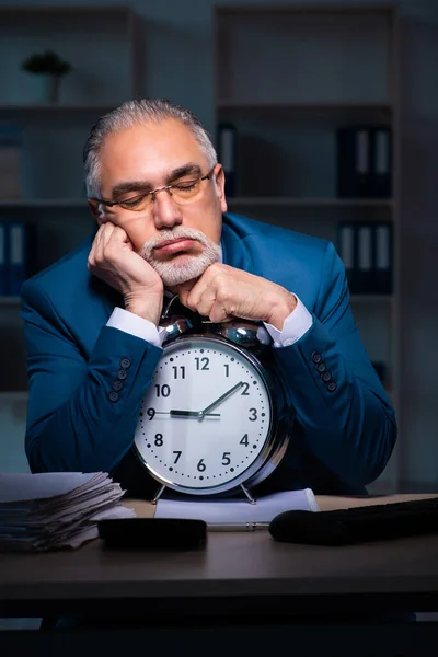 Velho empregado do sexo masculino trabalhando até tarde no escritório — Fotografia de Stock