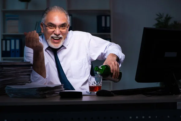 Old male employee working late in the office — Stock Photo, Image