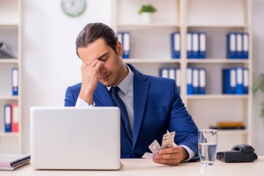 Genç bir erkek çalışan ve masanın üstünde bir sürü hap var.