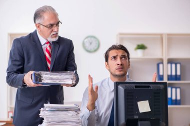 Eski patron ve genç erkek çalışan ofiste.