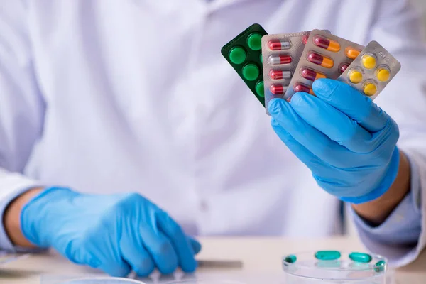 Joven asistente de laboratorio masculino en concepto de síntesis de fármacos —  Fotos de Stock