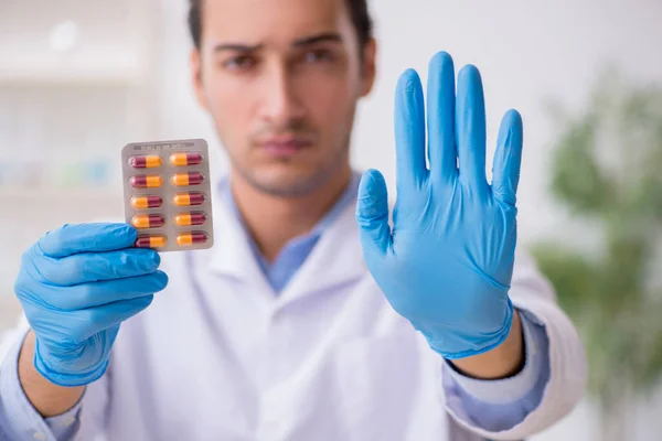 Jovem assistente de laboratório no conceito de síntese de drogas — Fotografia de Stock