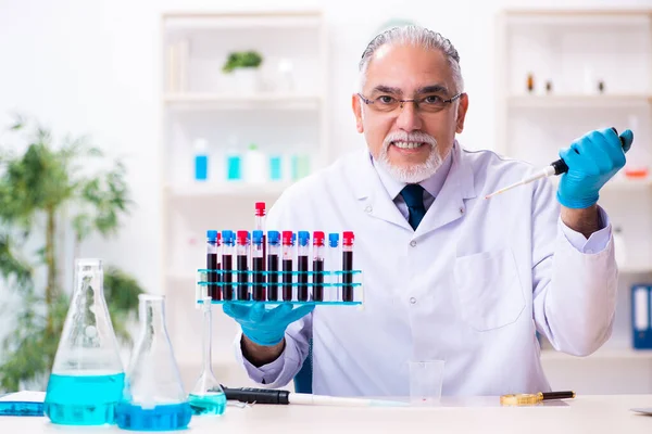 Oude mannelijke chemicus werkt in het lab. — Stockfoto