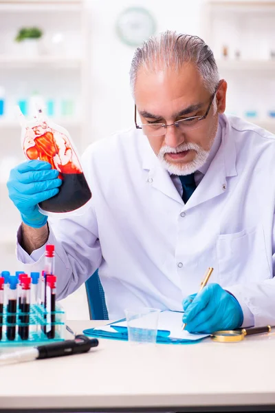 Oude mannelijke chemicus werkt in het lab. — Stockfoto