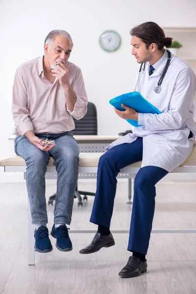 Ung manlig läkare och gammal patient i antirökningskoncept — Stockfoto