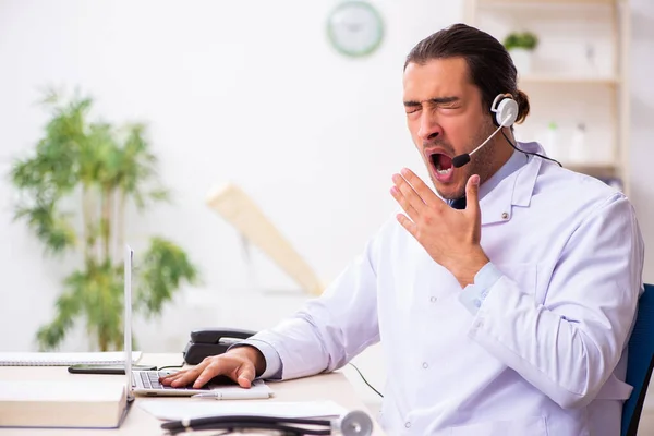 Junger Arzt hört Patient während telemedizinischer Sitzung zu — Stockfoto