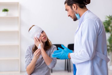 Genç baş yaralı kadın genç erkek doktoru ziyaret ediyor.