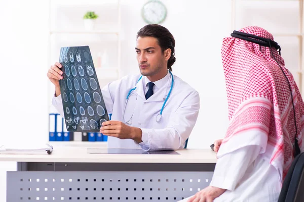 Old male arab visiting young male doctor — Stock fotografie