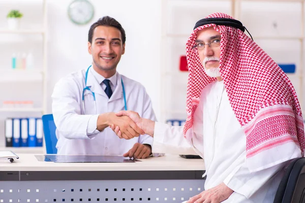 Velho árabe masculino visitando jovem médico masculino — Fotografia de Stock